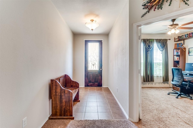 foyer entrance with light carpet and ceiling fan