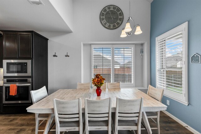 dining area featuring dark hardwood / wood-style flooring and a chandelier