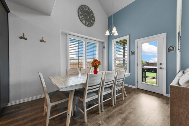 dining area featuring high vaulted ceiling, dark hardwood / wood-style floors, and a chandelier