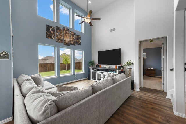 living room with hardwood / wood-style floors, a high ceiling, and ceiling fan