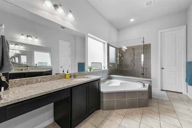 bathroom with vanity, tile patterned flooring, and plus walk in shower