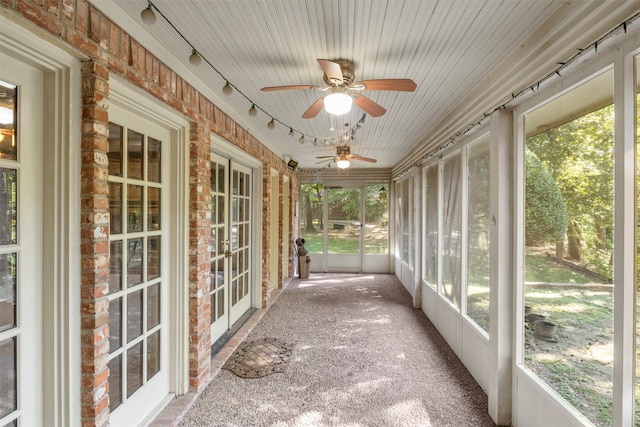 unfurnished sunroom featuring ceiling fan