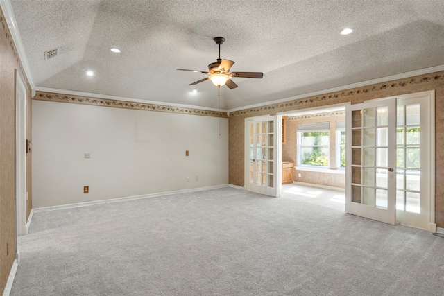 carpeted spare room featuring ceiling fan, french doors, ornamental molding, and a textured ceiling