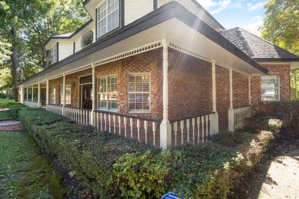 view of side of home featuring covered porch