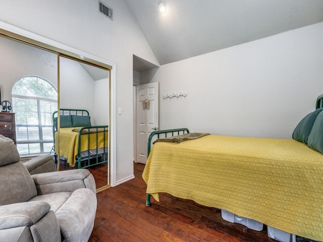 bedroom with dark wood-type flooring and high vaulted ceiling