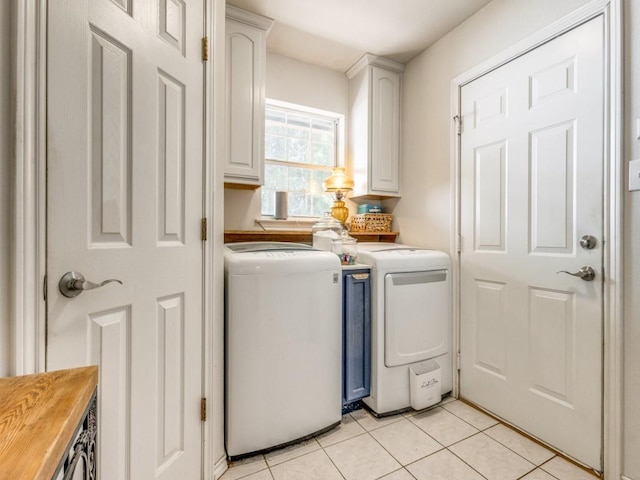 laundry area featuring cabinets, washing machine and dryer, and light tile patterned flooring