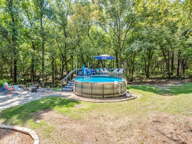 view of pool featuring a patio and a yard