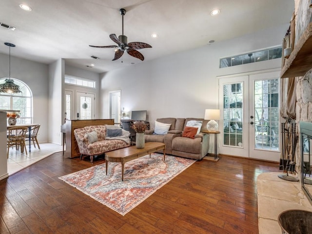 living room with dark wood-type flooring, ceiling fan, and french doors