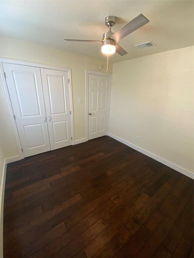 unfurnished bedroom with a closet, ceiling fan, and dark hardwood / wood-style flooring