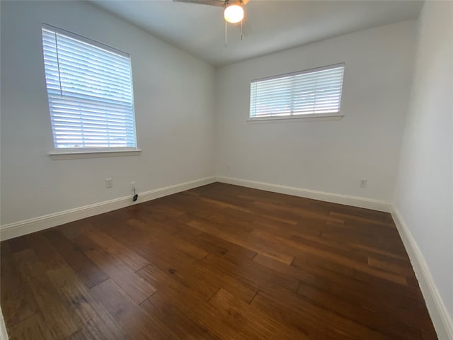 unfurnished room with ceiling fan, dark wood-type flooring, and a healthy amount of sunlight