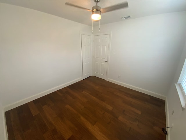 empty room with ceiling fan and dark hardwood / wood-style floors