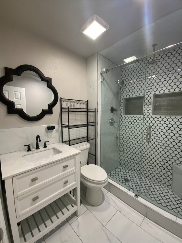 bathroom with tile patterned flooring, vanity, walk in shower, and toilet