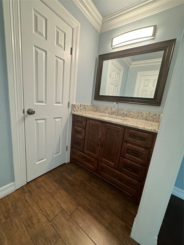 bathroom with hardwood / wood-style flooring, crown molding, and vanity