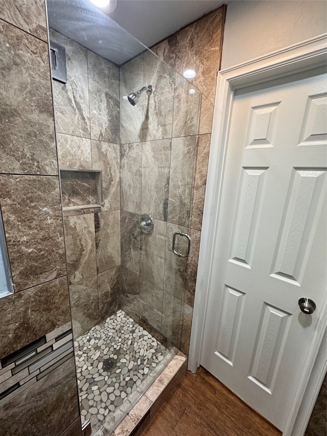 bathroom with an enclosed shower and wood-type flooring