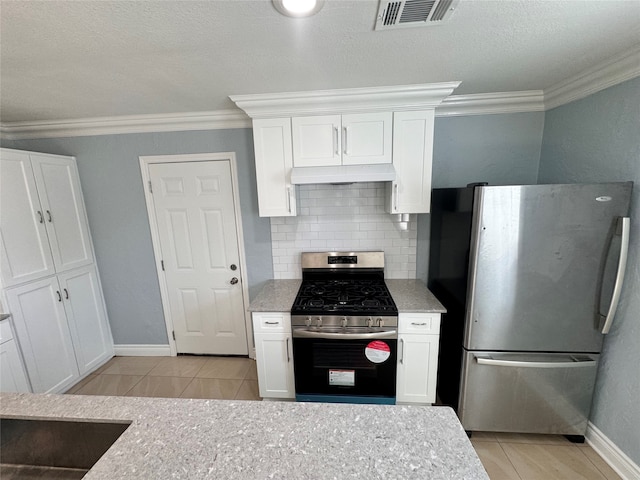 kitchen with ornamental molding, appliances with stainless steel finishes, tasteful backsplash, premium range hood, and white cabinets