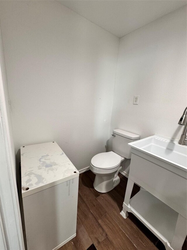 bathroom featuring toilet, hardwood / wood-style flooring, and vanity