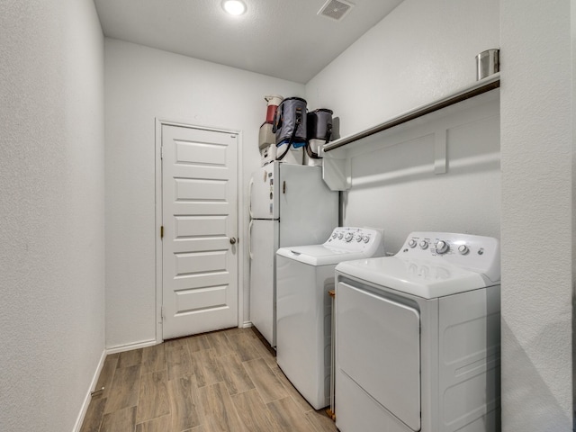 washroom featuring light wood-type flooring and washing machine and clothes dryer