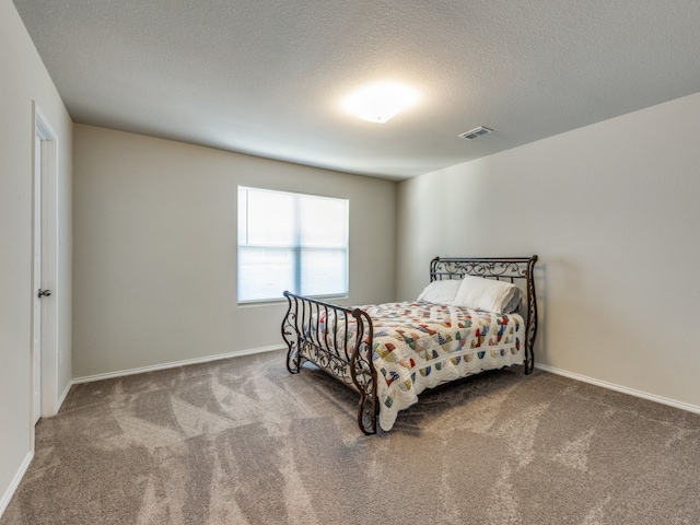 bedroom with a textured ceiling and carpet flooring