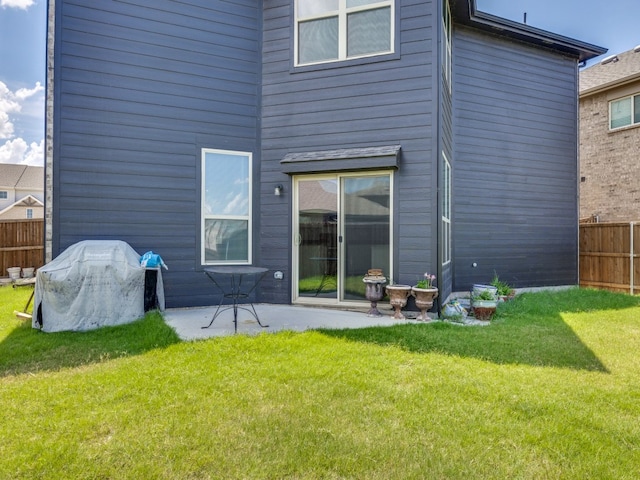 rear view of house with a lawn and a patio area