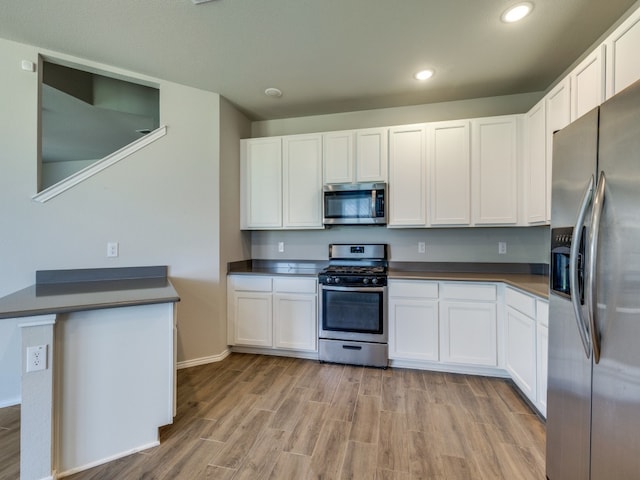 kitchen with white cabinets, light hardwood / wood-style flooring, and appliances with stainless steel finishes