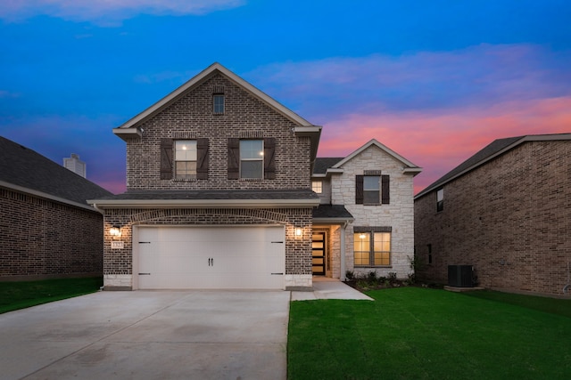 view of front property with central AC unit, a garage, and a lawn