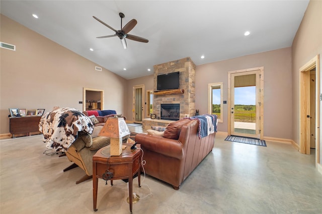 living area with visible vents, lofted ceiling, recessed lighting, a stone fireplace, and concrete flooring