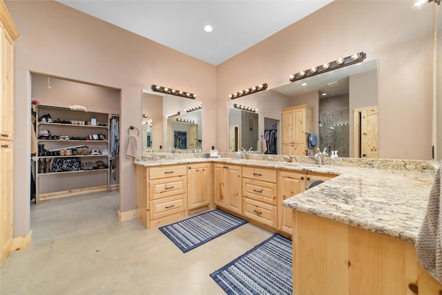 bathroom with a walk in closet, vanity, and a shower stall