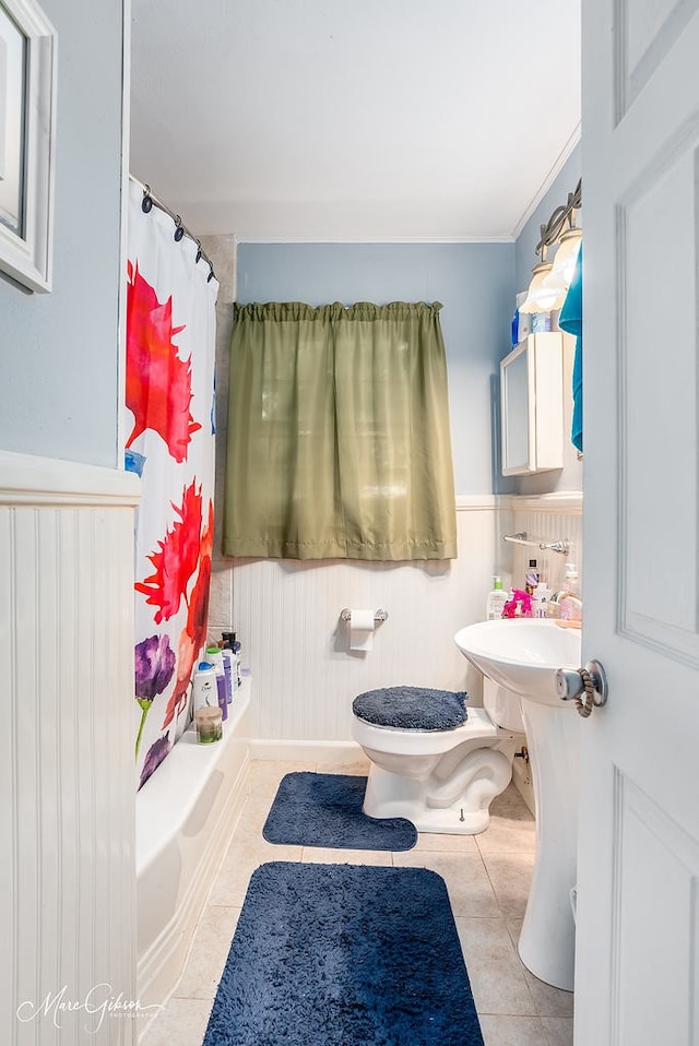 bathroom with shower / bath combo with shower curtain, tile patterned floors, and toilet