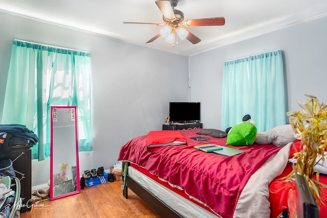 bedroom featuring ornamental molding, hardwood / wood-style flooring, and ceiling fan