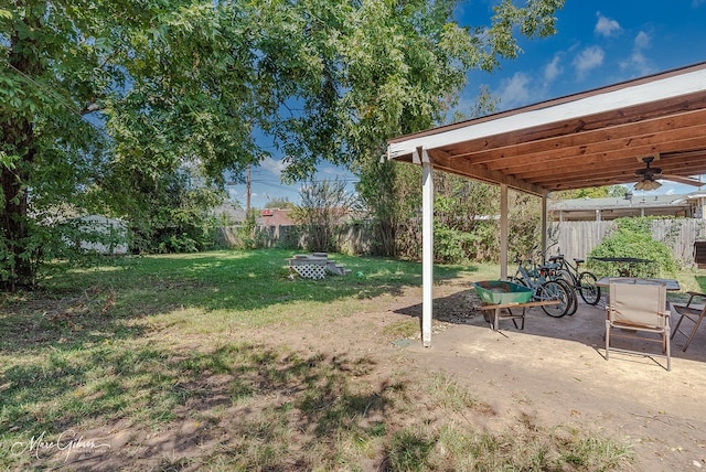 view of yard featuring a fire pit, a patio area, and ceiling fan