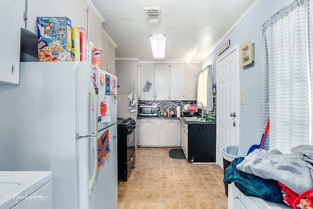 kitchen with sink, white fridge, black range with gas cooktop, and white cabinetry