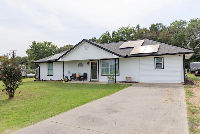 view of front of home with a porch, a front yard, and solar panels