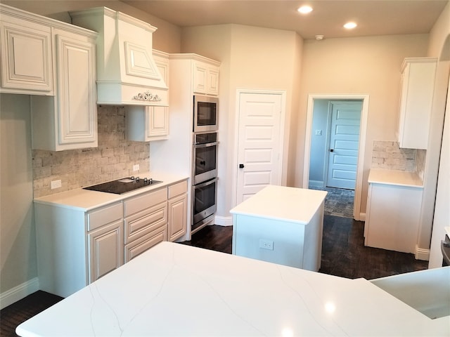 kitchen featuring white cabinets, dark hardwood / wood-style flooring, stainless steel appliances, and premium range hood