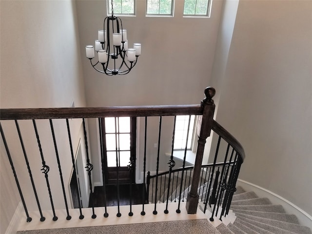 staircase with carpet and a chandelier