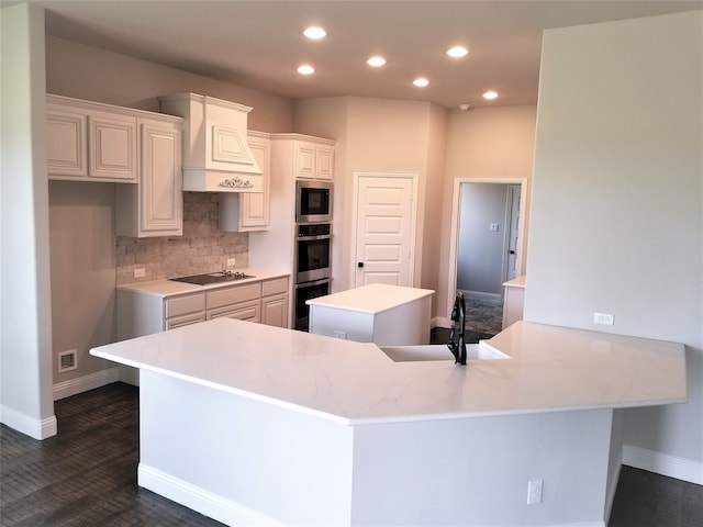 kitchen with sink, tasteful backsplash, kitchen peninsula, white cabinets, and appliances with stainless steel finishes