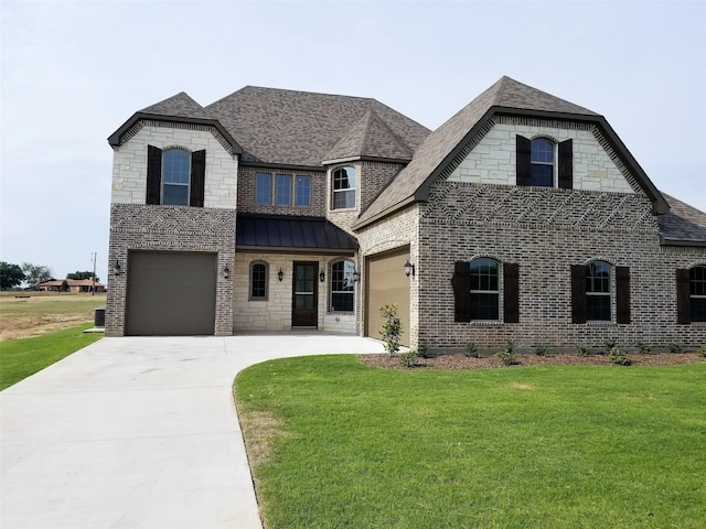 french provincial home with a front lawn and a garage