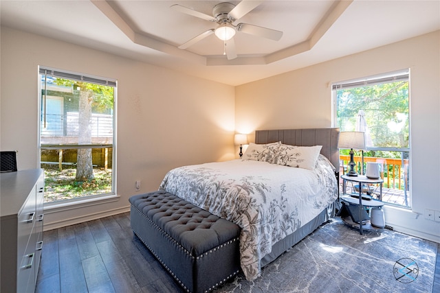 bedroom featuring a tray ceiling, ceiling fan, and dark hardwood / wood-style floors