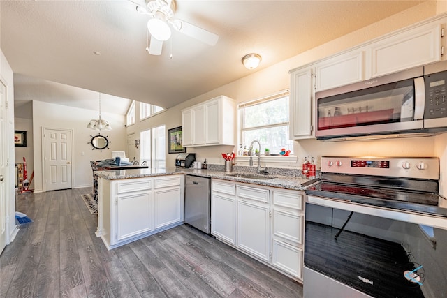 kitchen featuring dark hardwood / wood-style floors, white cabinetry, appliances with stainless steel finishes, sink, and kitchen peninsula