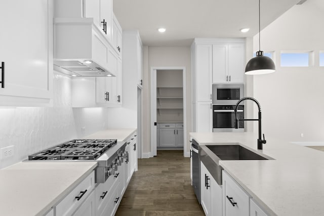 kitchen with white cabinets, stainless steel gas cooktop, built in microwave, and hanging light fixtures