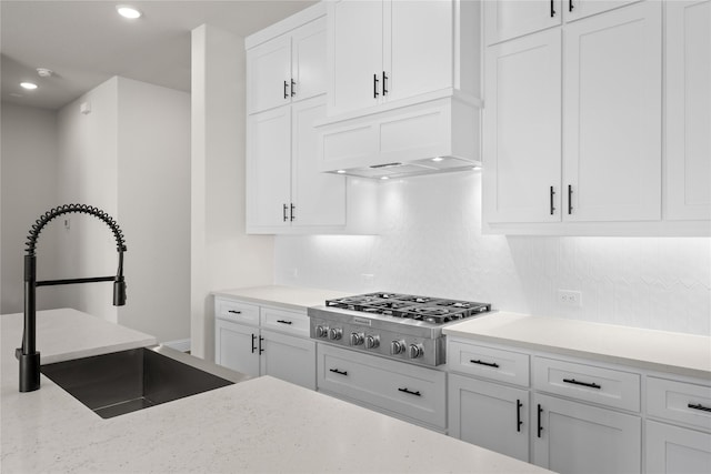 kitchen featuring sink, white cabinets, stainless steel gas cooktop, tasteful backsplash, and custom exhaust hood