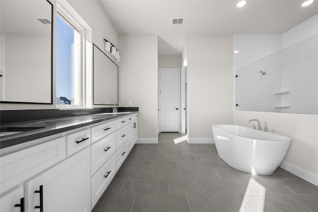 bathroom featuring vanity, tile patterned floors, plenty of natural light, and plus walk in shower