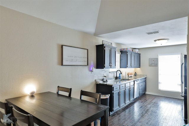 dining space with vaulted ceiling, dark hardwood / wood-style flooring, and sink