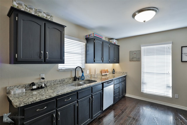 kitchen with dark wood-type flooring, light stone counters, sink, and dishwasher