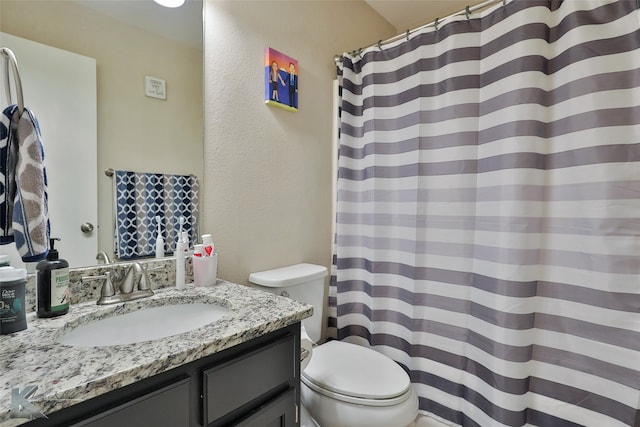 bathroom featuring vanity, toilet, and curtained shower