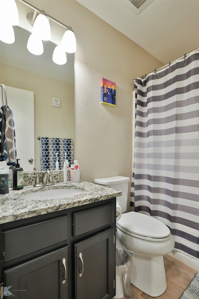 bathroom with tile patterned flooring, vanity, toilet, and curtained shower