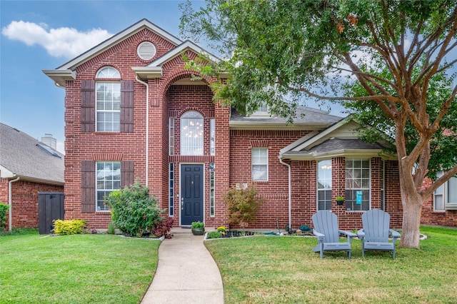 traditional home with brick siding and a front lawn