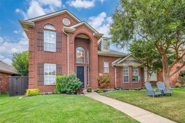 traditional-style home with brick siding and a front lawn