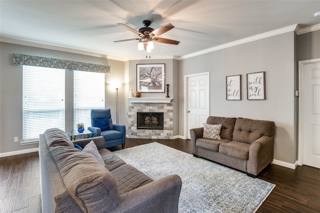 living room with a stone fireplace, ceiling fan, dark wood-type flooring, and crown molding