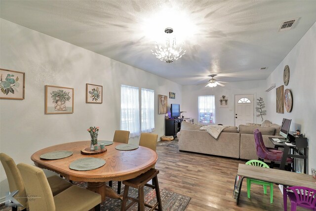 dining room with ceiling fan with notable chandelier and hardwood / wood-style floors