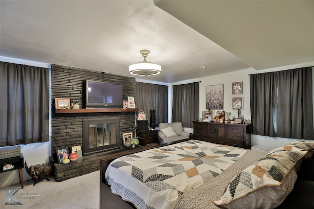 carpeted bedroom with a stone fireplace